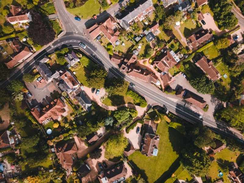 Aerial view of an established neighborhood with mature trees and diverse homes reflecting gradual community growth over time.