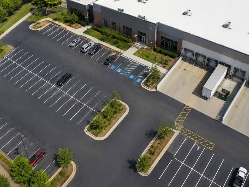 Aerial view of striped parking stalls and loading areas at a Birmingham commercial property reviewed for an ALTA survey.