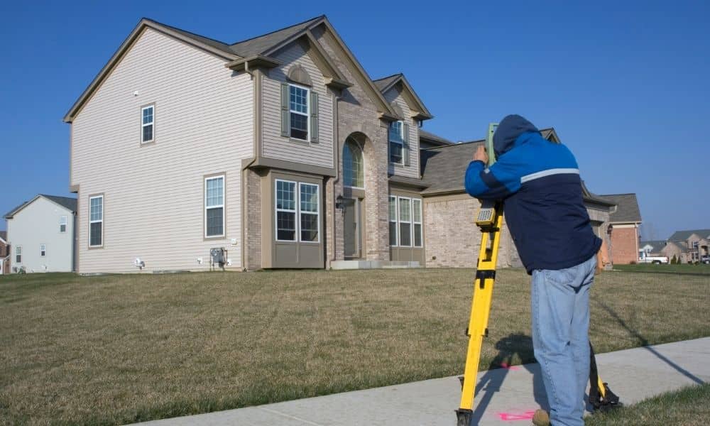 Land surveyor measuring a residential property for an Elevation Certificate in Birmingham, Alabama